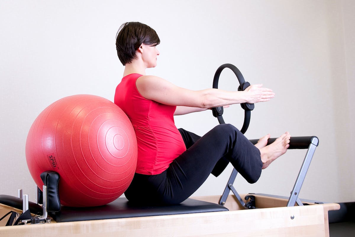 Woman in Red Top Leaning on Red Stability Ball